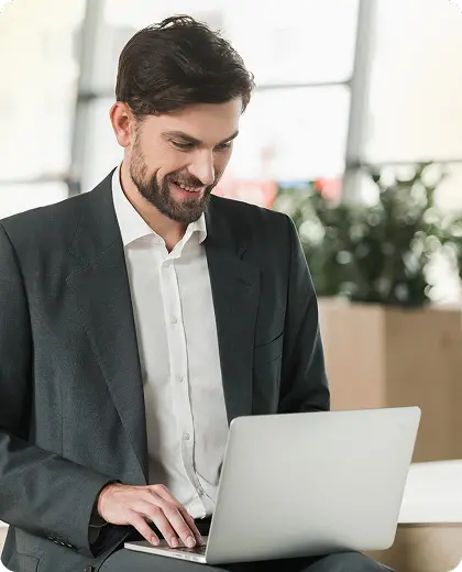 Person working on a laptop with a smile on the face
